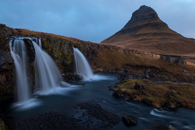 Foto gratuita hermosa foto de grandes cascadas y una montaña con un cielo azul