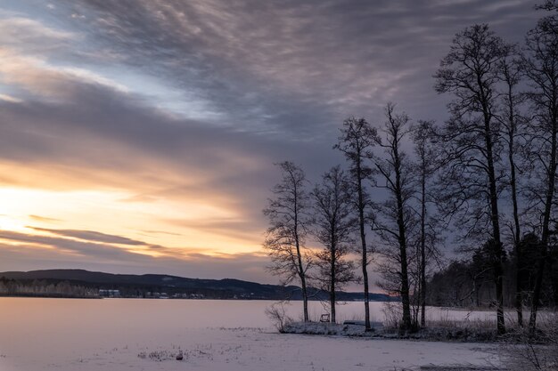 Hermosa foto de un lago congelado con un paisaje de puesta de sol en el cielo