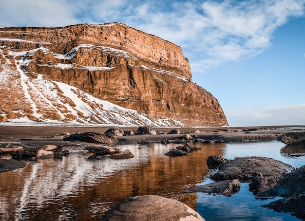 Hermosa foto de un lago frente a una montaña nevada con cielo azul