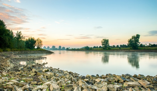 Hermosa foto de un lago tranquilo rodeado de árboles durante una puesta de sol