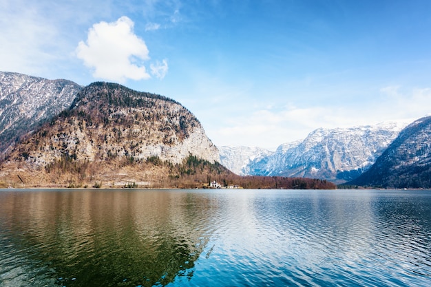 Hermosa foto de un lago tranquilo rodeado de colinas bajo un cielo azul