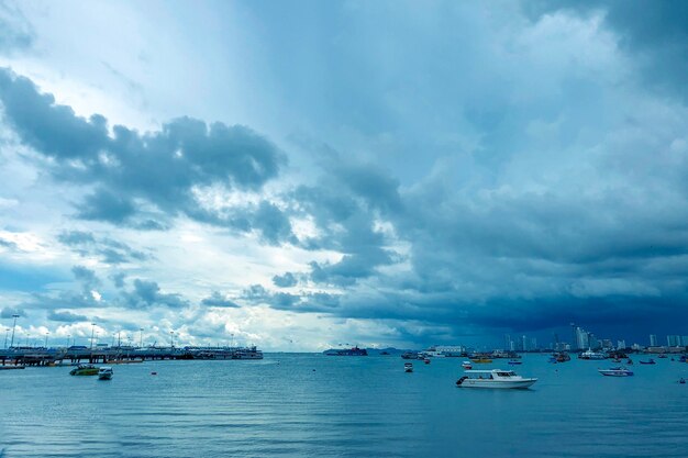 Hermosa foto de un mar con barcos bajo un cielo nublado azul