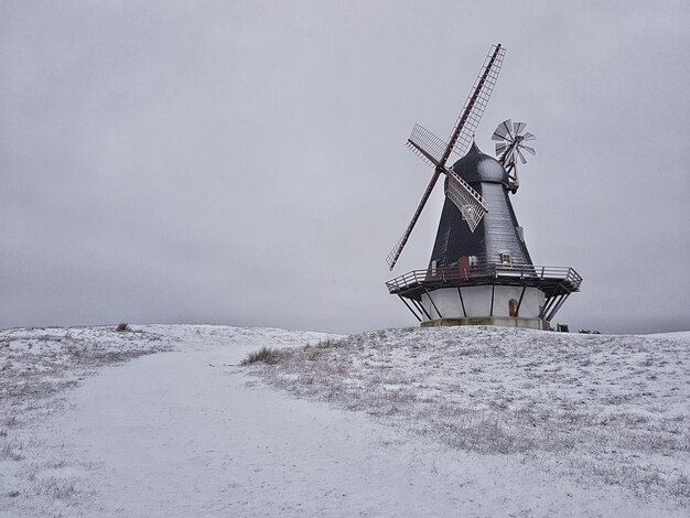 Hermosa foto de un molino de viento en medio de un campo de invierno