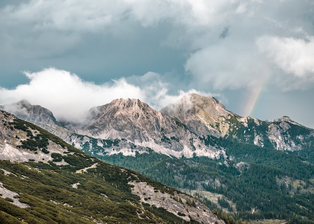 Hermosa foto de la montaña boscosa bajo un cielo nublado azul en Grober priel