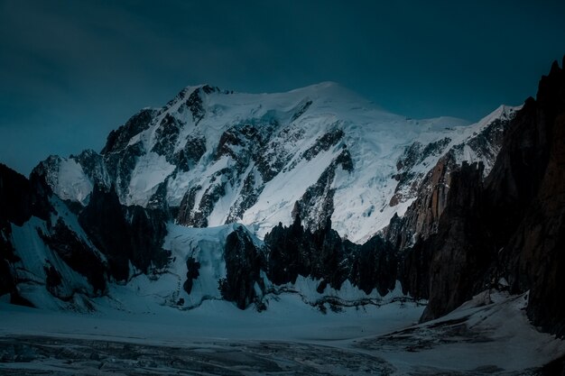 Hermosa foto de una montaña nevada con un cielo azul oscuro