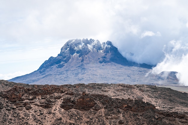 Hermosa foto de una montaña con las nubes creando una atmósfera brumosa