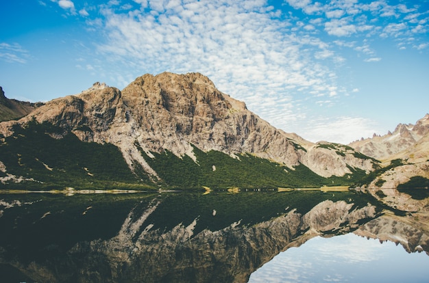 Foto gratuita hermosa foto de una montaña rocosa junto a un lago con reflejo en el agua