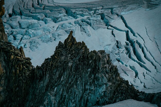 Hermosa foto de montañas y colinas nevadas y rocosas empinadas