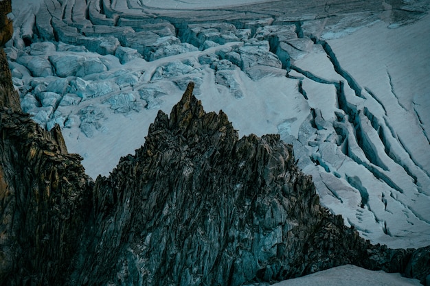 Hermosa foto de montañas y colinas nevadas y rocosas empinadas