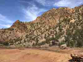 Foto gratuita hermosa foto de montañas cubiertas de árboles con un cielo azul nublado