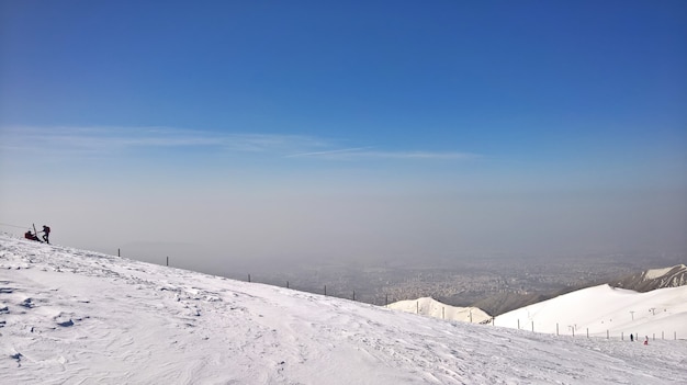 Hermosa foto de montañas nevadas y dos personas a la izquierda