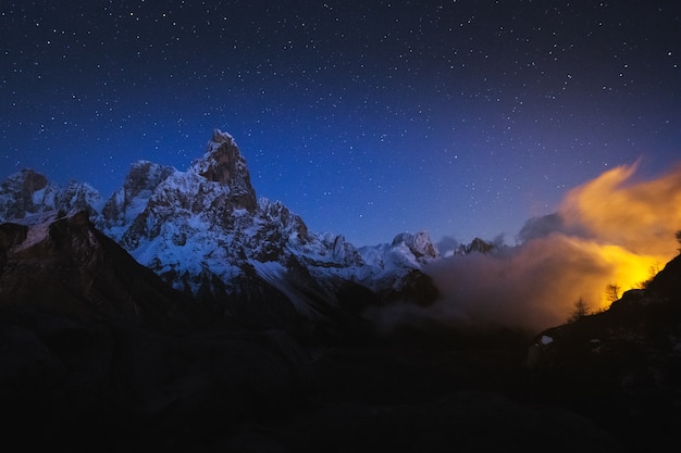 Hermosa foto de montañas rocosas con un cielo nocturno estrellado de fondo