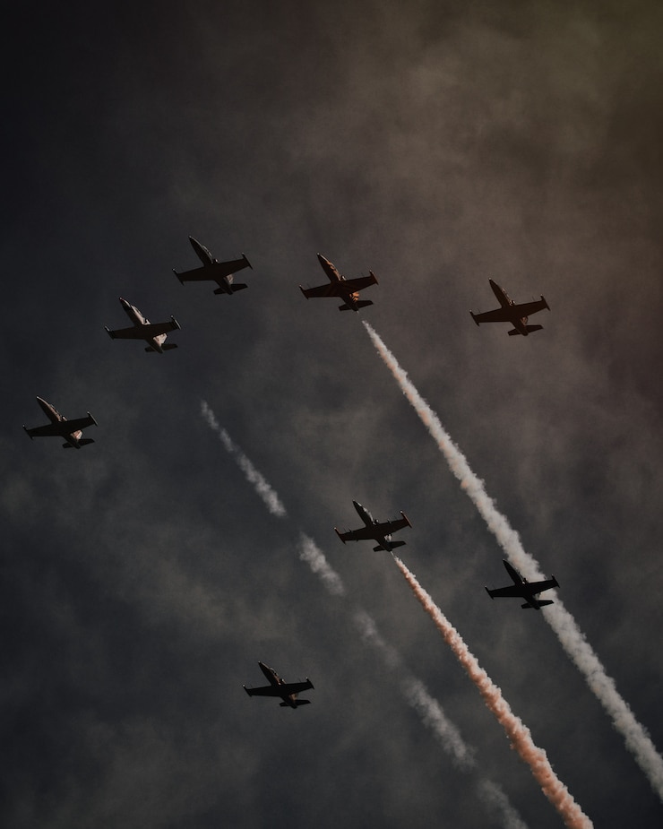 Foto gratuito hermosa foto de muchos aviones en el cielo gris realizando operaciones y piruetas