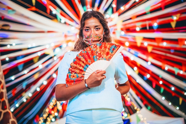 Foto gratuita hermosa foto de mujer europea bronceada con una máscara floral en un parque de atracciones