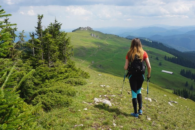 Hermosa foto de una mujer excursionista de senderismo en la montaña bajo el cielo azul en verano