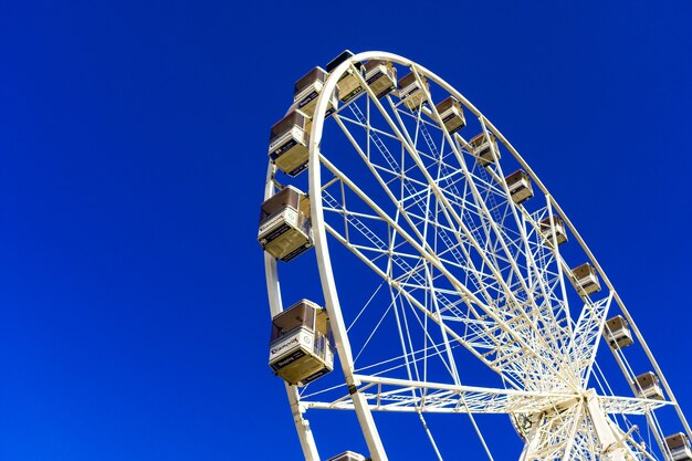 Hermosa foto de una noria en el parque de atracciones contra el cielo azul