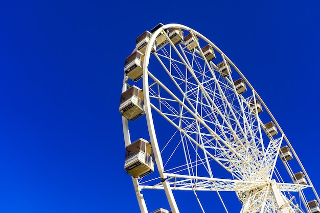 Hermosa foto de una noria en el parque de atracciones contra el cielo azul