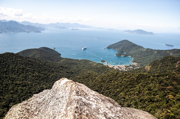 Hermosa foto de una orilla del mar con montañas boscosas en Pico de Papagayo, Ilha Grande, Brasil