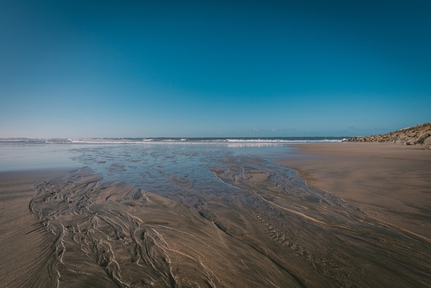 Hermosa foto de la orilla de una playa bajo un cielo azul