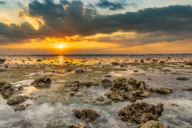 Hermosa foto de un paisaje de puesta de sol en la orilla del mar