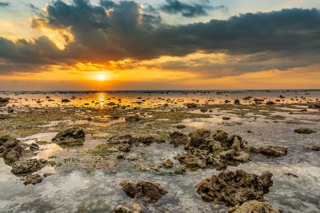 Hermosa foto de un paisaje de puesta de sol en la orilla del mar