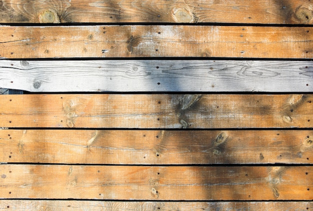 Hermosa foto de una pared de madera con una sombra en la superficie