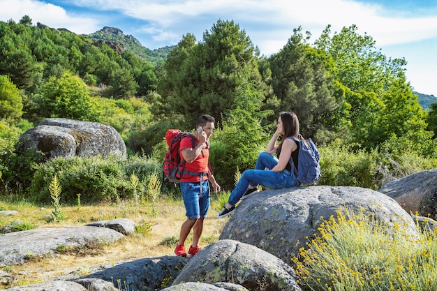 Hermosa foto de una pareja feliz sentada en la roca mientras disfruta del fresco