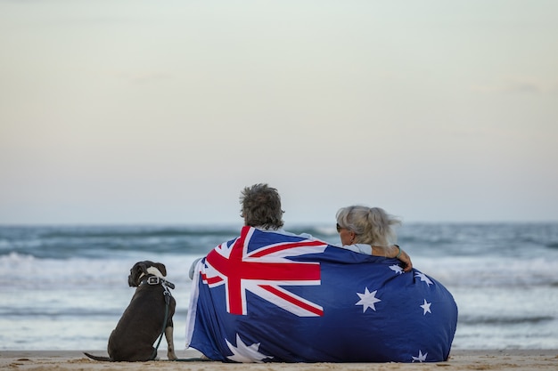 Hermosa foto de una pareja en la playa con perro Stafford inglés azul