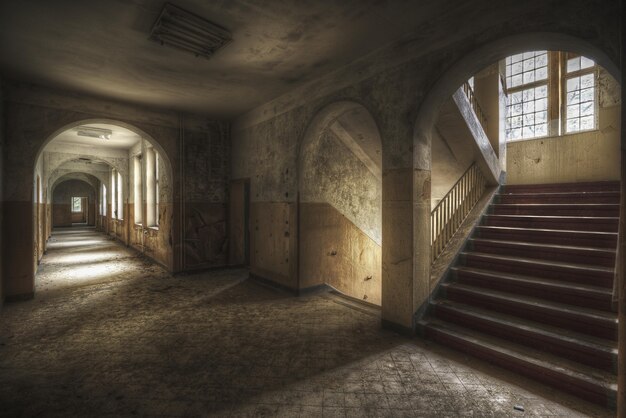 Hermosa foto de un pasillo con escaleras y ventanas en un edificio antiguo