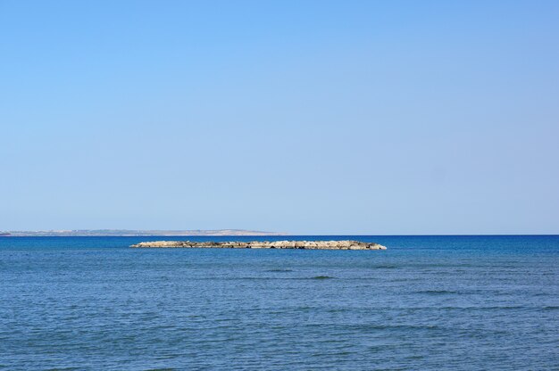 Hermosa foto de una pequeña isla cubierta de rocas en medio de un lago