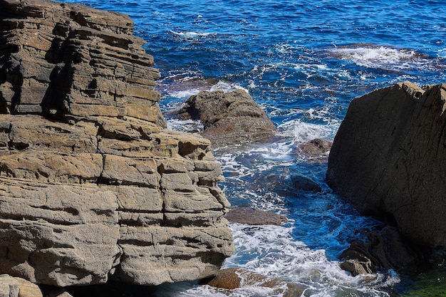 Hermosa foto de piedra en el mar con ola