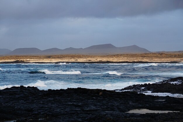 Hermosa foto de la playa rocosa y las montañas de Fuerteventura, España