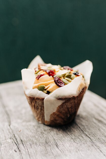 Hermosa foto de primer plano de un delicioso panecillo con frutas y semillas de calabaza en una superficie de madera