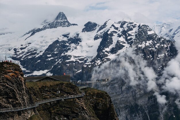 Hermosa foto de un puente cerca de montañas llenas de nieve