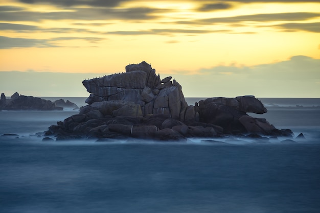 Foto gratuita hermosa foto de rocas en la orilla del mar durante la puesta de sol