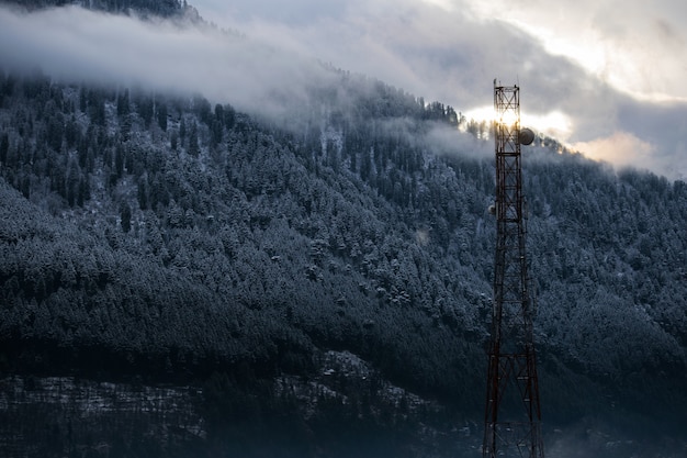 Foto gratuita hermosa foto de una torre de radio sobre un fondo de bosque nevado