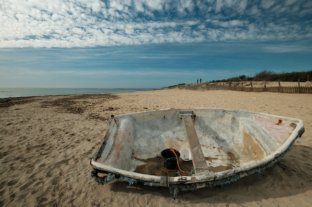 Foto gratuita hermosa foto de un viejo barco de pesca en la playa en un día soleado