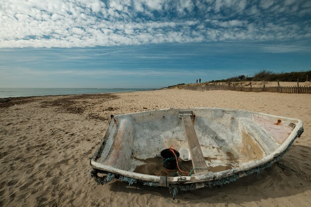 Hermosa foto de un viejo barco de pesca en la playa en un día soleado