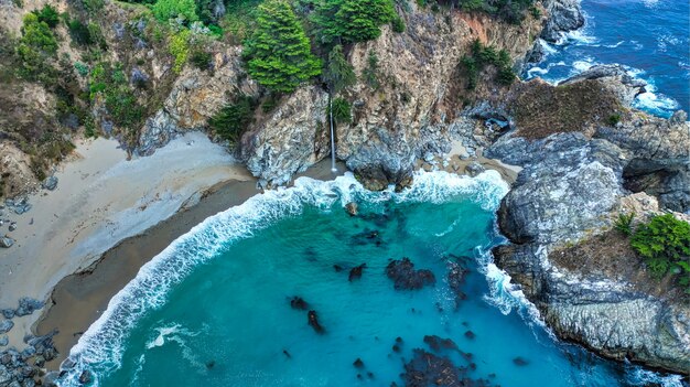 Hermosa fotografía aérea de la costa del mar con olas increíbles en un día soleado