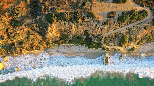 Hermosa fotografía aérea de la costa del mar con olas increíbles en un día soleado