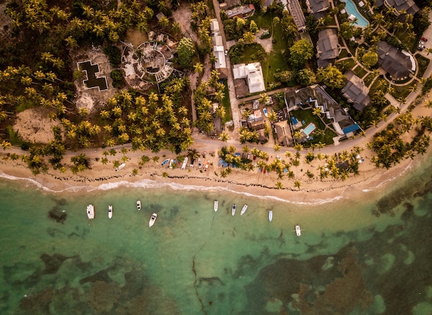 Hermosa fotografía cenital de casas y pequeñas embarcaciones estacionadas cerca de la orilla del mar