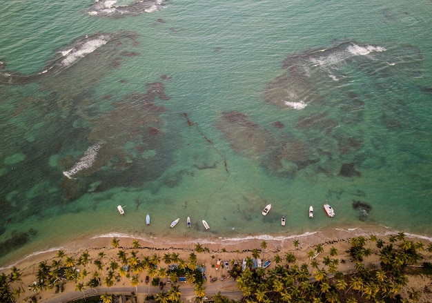 Foto gratuita hermosa fotografía cenital de la costa del mar con algunos pequeños botes estacionados cerca de la orilla