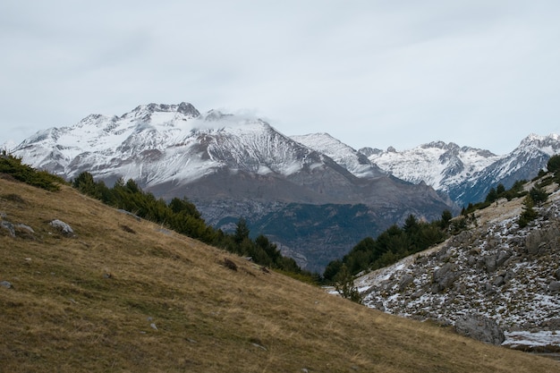 Hermosa gama de altas montañas rocosas cubiertas de nieve durante el día