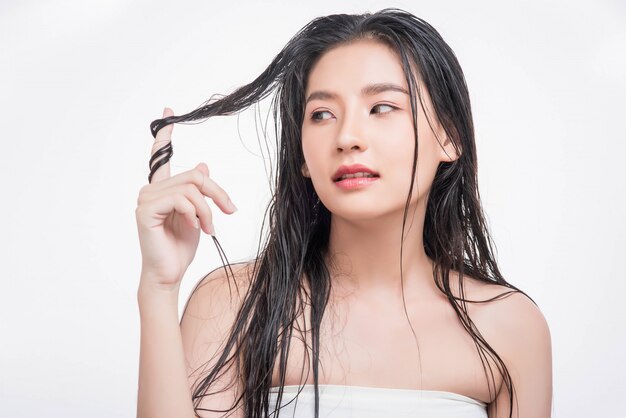 Una hermosa, hermosa mujer atrapa su cabello desordenado.