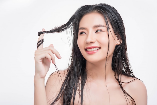 Una hermosa, hermosa mujer atrapa su cabello desordenado.