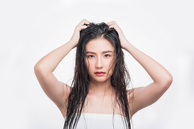 Una hermosa, hermosa mujer atrapa su cabello desordenado.