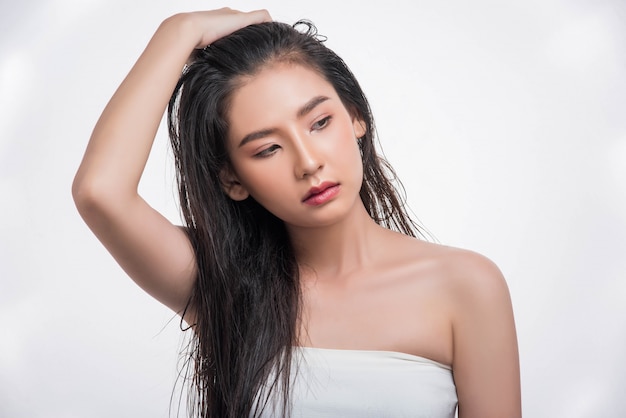 Una hermosa, hermosa mujer atrapa su cabello desordenado.