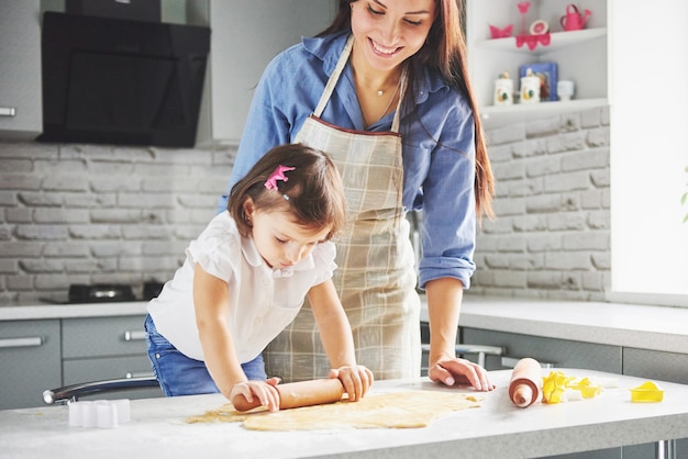 Una hermosa hija con su madre cocinando en la cocina