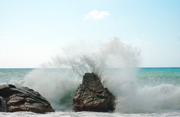 Hermosa imagen de fuertes olas rompiendo en las rocas en la orilla