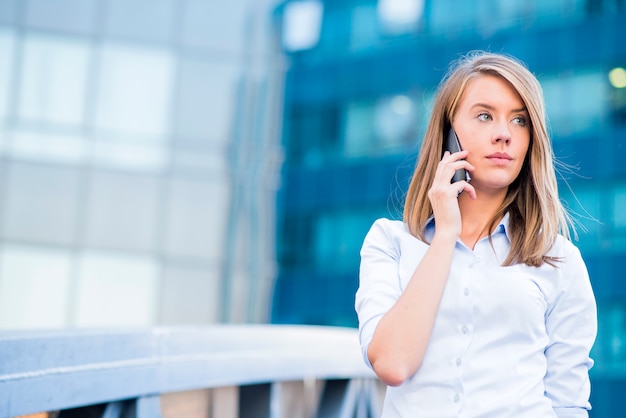 Una hermosa joven agente de bienes raíces mujer en el teléfono